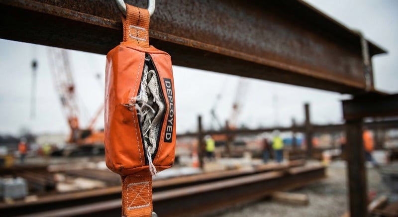 Close-up of a shock absorber pack on a fall arrest lanyard showing the deployment indicator