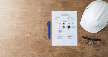 Safety supervisor reviewing incident report files in a construction site office — record keeping and document management for workplace compliance